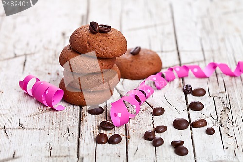 Image of fresh chocolate cookies, coffee beans and pink ribbons