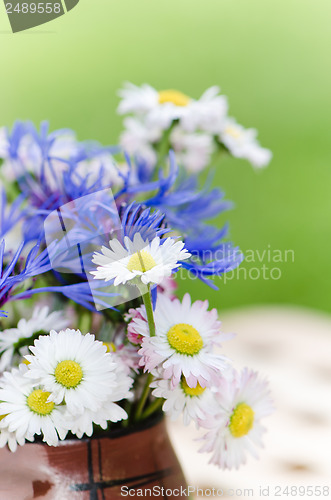 Image of Bouquet of daisies on the table in the garden. Summer background