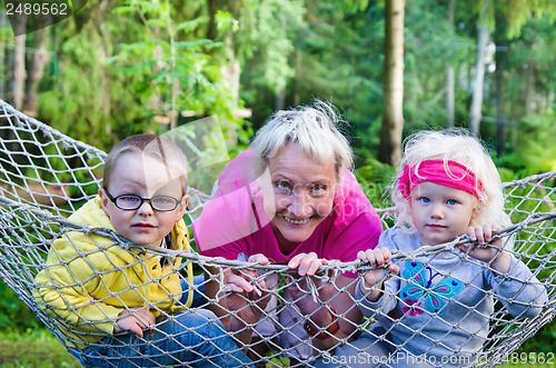 Image of Children with grandmother swinging in a hammock, close-up  