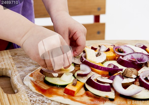 Image of small hands preparing pizza