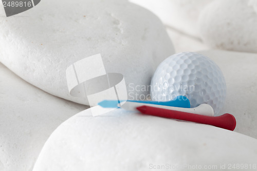 Image of Golf ball and tees between white stones