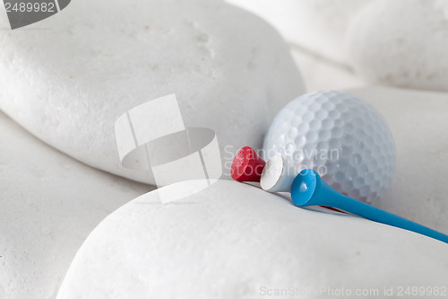 Image of Golf ball and tees between white stones