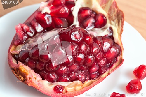 Image of The cut pomegranate and grains on a plate