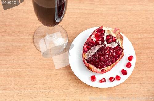 Image of Goblet of wine and a pomegranate on the table