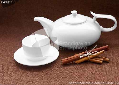 Image of teapot, cup and cinnamon on sacking