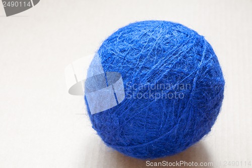 Image of blue wool yarn skein on cardboard background