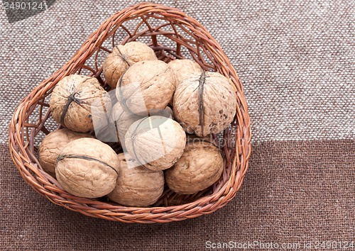 Image of Walnuts in the old wicker basket on burlap