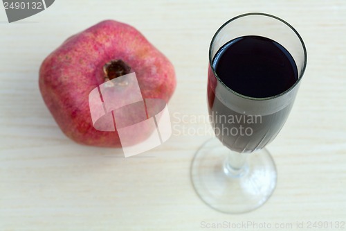 Image of Goblet of wine and a pomegranate on the table