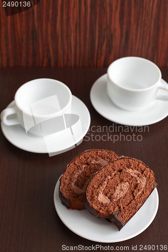 Image of chocolate cake on a plate with a cup