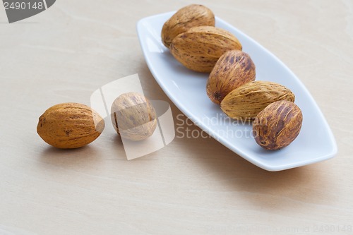 Image of brown nuts lying in a row on a platter