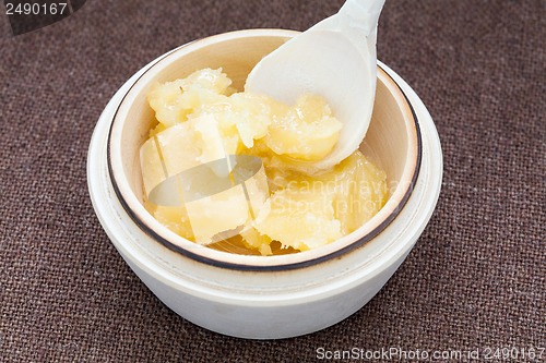 Image of Pot of honey and wooden spoon on a bagging