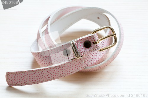 Image of pink women style belt on a light wooden background