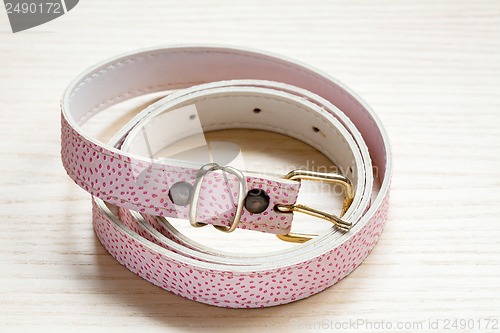 Image of pink women style belt on a light wooden background