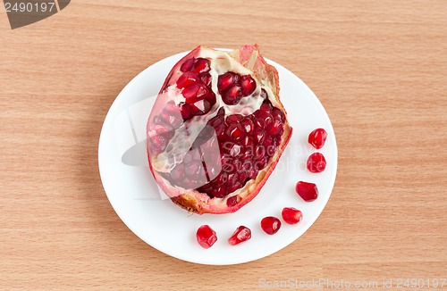 Image of The cut pomegranate and grains on a plate