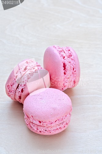 Image of pink macaron on wooden background