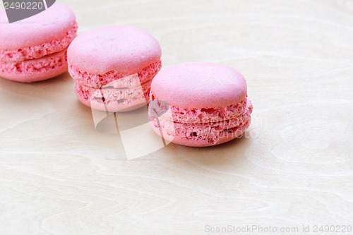 Image of pink macaron on wooden background