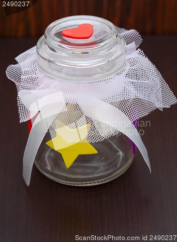 Image of empty jar with a bow on a wooden background