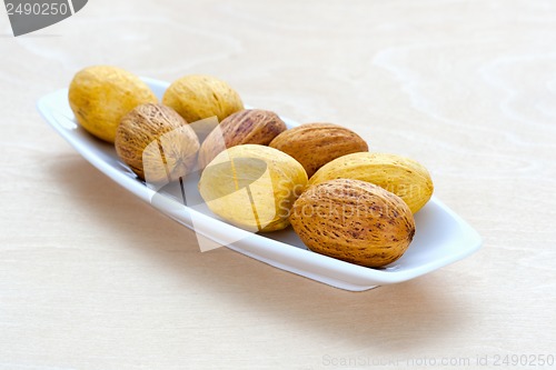 Image of brown nuts lying in a row on a platter