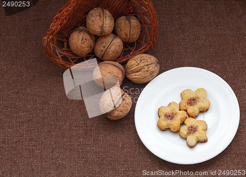 Image of wicker basket with nuts and pastry on a plate