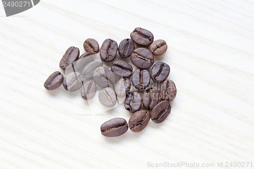 Image of coffee beans on white wooden background