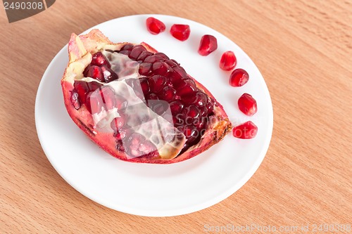 Image of The cut pomegranate and grains on a plate