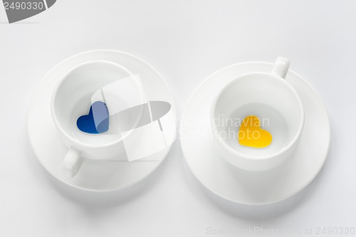 Image of empty cup and saucer with hearts