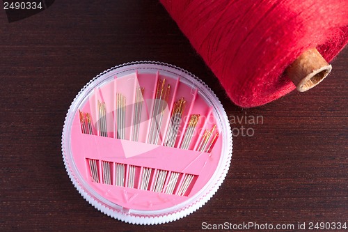 Image of pack of needles and a skein of thread