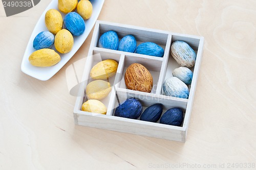 Image of dish with nuts next to the box full of nuts
