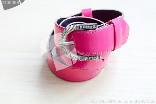 Image of A pink women belts on a light wooden background