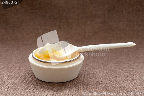 Image of Pot of honey and wooden dipper on a sackcloth