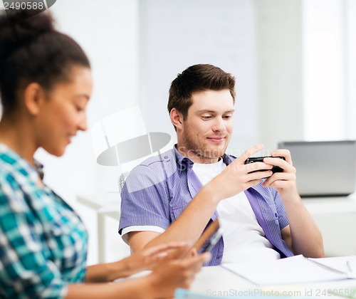 Image of students looking at devices at school