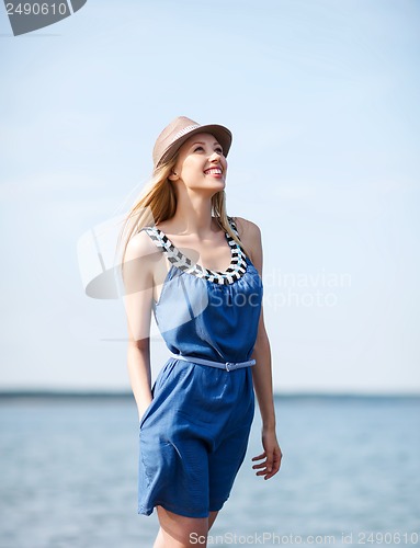 Image of girl in hat walking on the beach