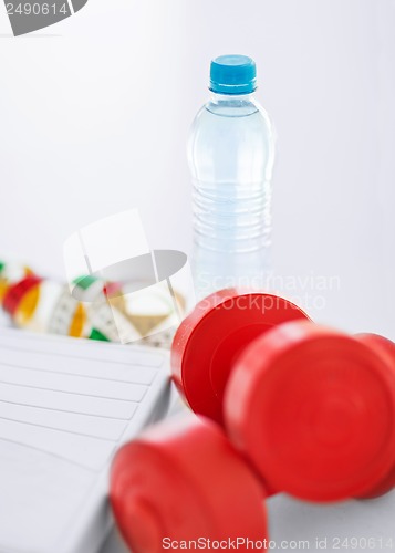 Image of scales, dumbbells, bottle of water, measuring tape