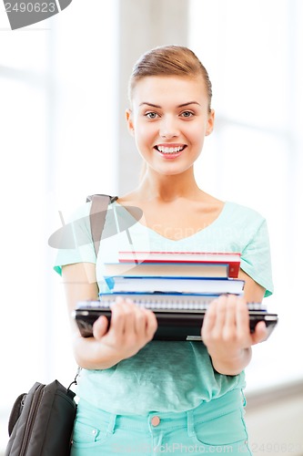 Image of student with folders and school bag in college