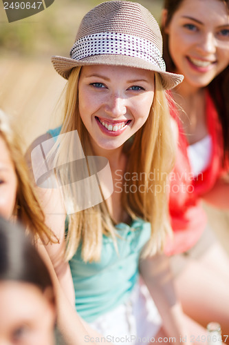 Image of girl with drink and friends on the beach