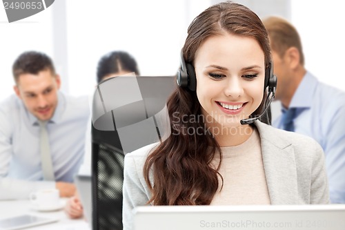 Image of helpline operator with headphones in call centre