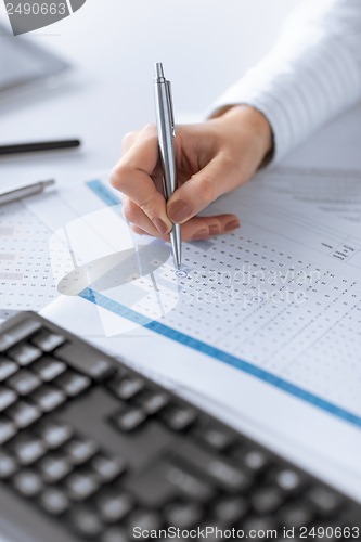 Image of woman hand writing on paper with numbers