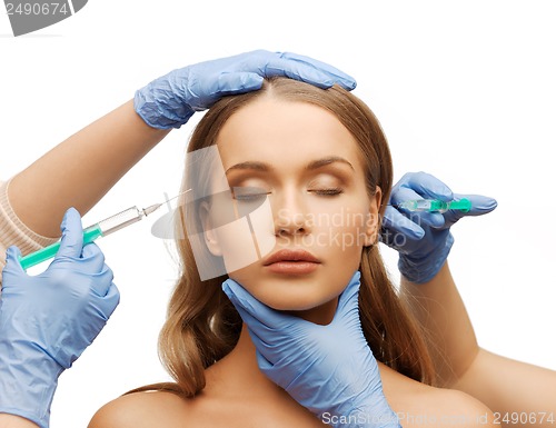 Image of woman face and beautician hands with syringe