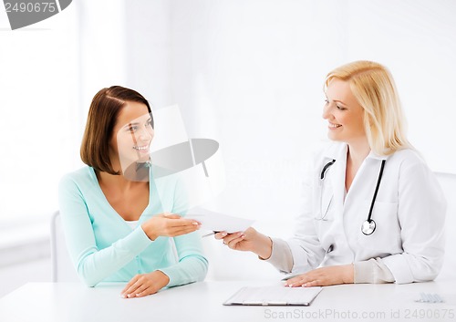 Image of doctor giving prescription to patient in hospital