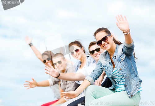 Image of group of teenagers waving hands