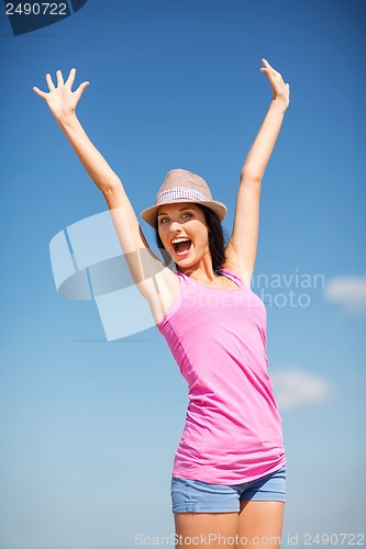 Image of girl with hands up on the beach