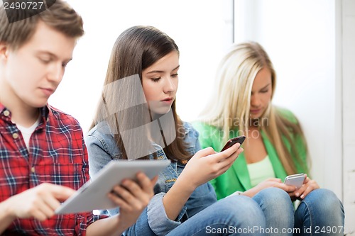 Image of students looking into devices at school