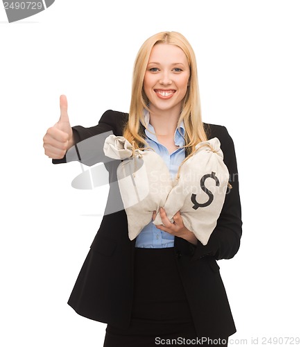 Image of businesswoman with money bags showing thumbs up