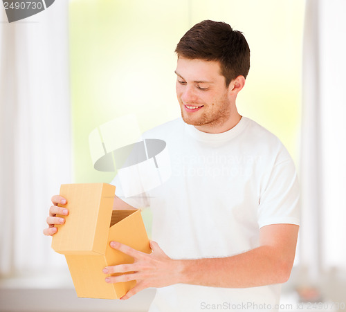 Image of man in white t-shirt with gift box