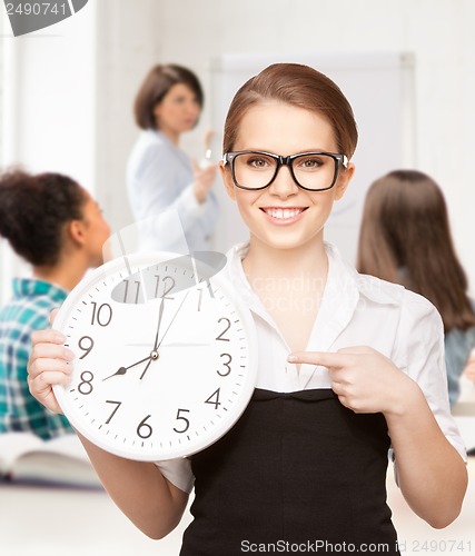 Image of attractive student pointing at clock