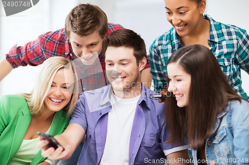 Image of students looking into smartphone at school
