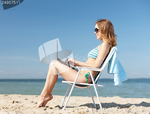 Image of girl looking at tablet pc on the beach