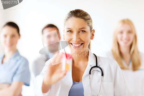 Image of female doctor with jar of capsules