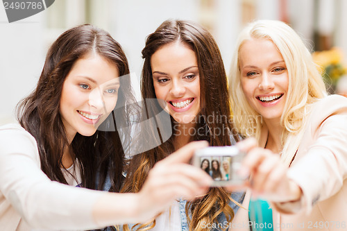 Image of beautiful girls taking picture in cafe in city