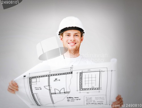 Image of male architect in helmet with blueprint